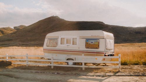 Camping Trailer on a Field with Hills in the Background 