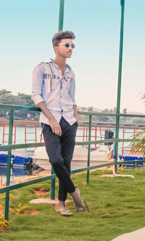 Man Standing In Park Near A River