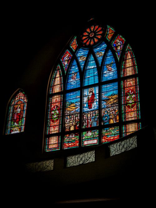 Free Beautiful stained glass windows depicting religious scenes in a gothic church setting. Stock Photo
