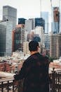 一名男子穿着休闲装，在桥上观察纽约市标志性的天际线