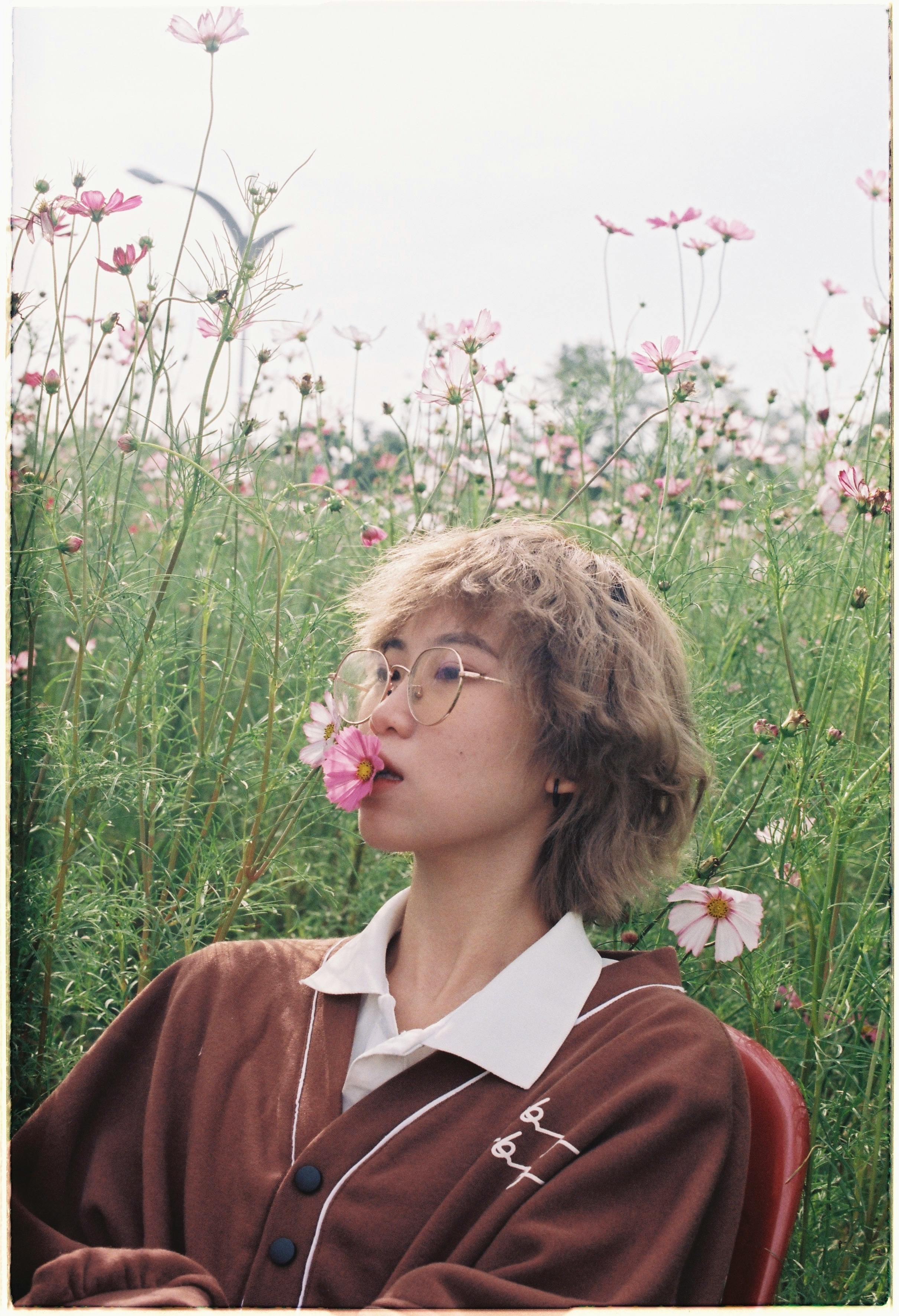 [ColoSach]-a-woman-with-eyeglasses-poses-in-a-vibrant-flower-field,-evoking-a-serene,-dreamy-vibe.