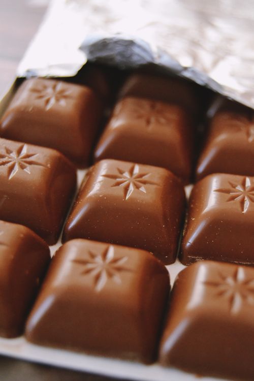 Free Indulge in these creamy milk chocolate squares wrapped in foil, perfectly captured in a close-up shot. Stock Photo