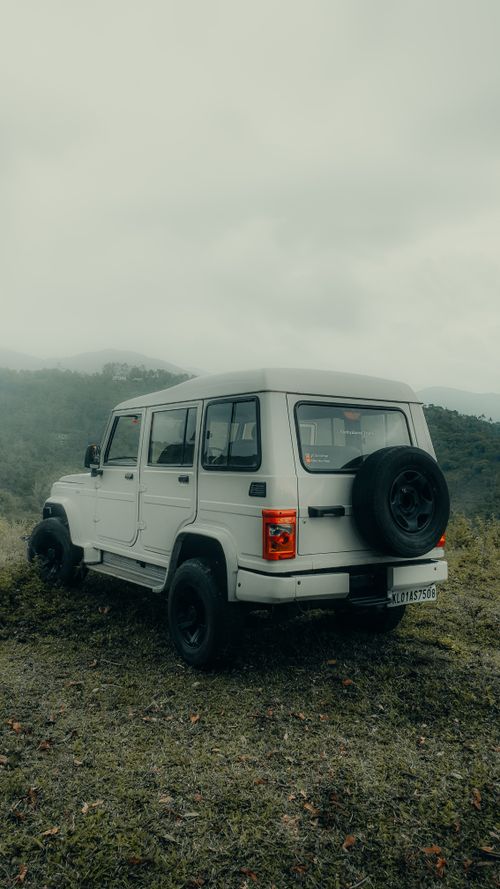 Free White 4x4 jeep parked on foggy green hills in Idukki, India, perfect for an adventure road trip. Stock Photo