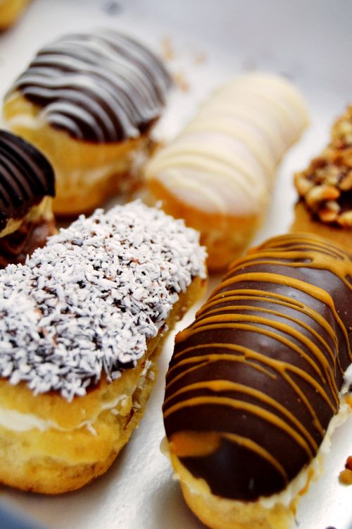 Free Close-up of assorted eclairs with chocolate, caramel, and coconut toppings. Stock Photo
