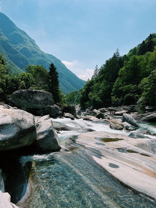 Free Beautiful view of Verzasca Valley stream with rapids, rocks, and forested mountains in Switzerland. Stock Photo