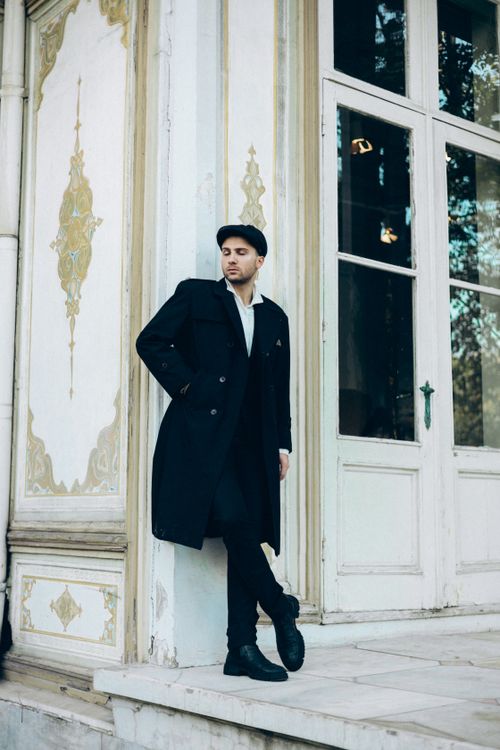Free Fashionable man leans against ornate wall in urban Turkey setting. Stock Photo