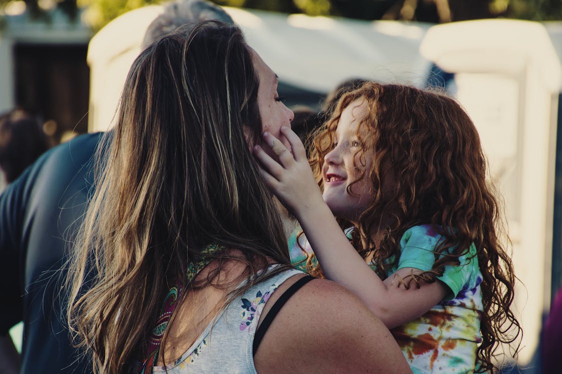 Free Woman Carrying Girl While Showing Smile Stock Photo