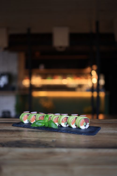Free A beautifully presented sushi roll on a wooden table in a stylish restaurant setting, offering a gourmet experience. Stock Photo