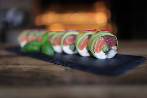 Free Delicious sushi rolls with salmon and avocado, beautifully plated on a slate surface. Stock Photo