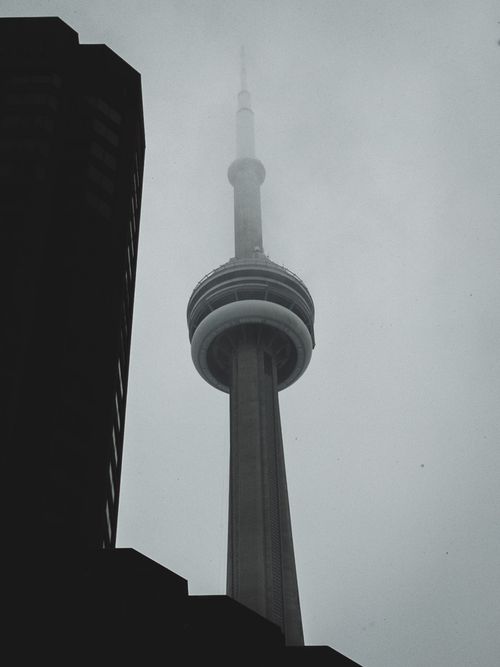 Free A foggy day view of the iconic CN Tower towering above Toronto cityscape. Stock Photo
