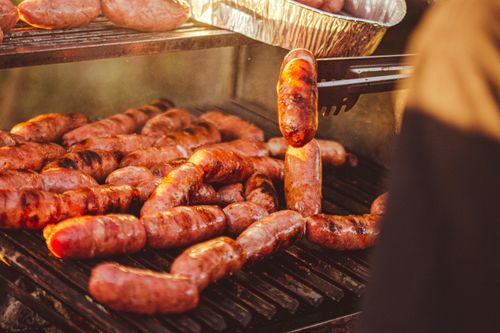 Free Juicy grilled sausages sizzling on a barbecue grill, capturing the essence of outdoor cooking. Stock Photo