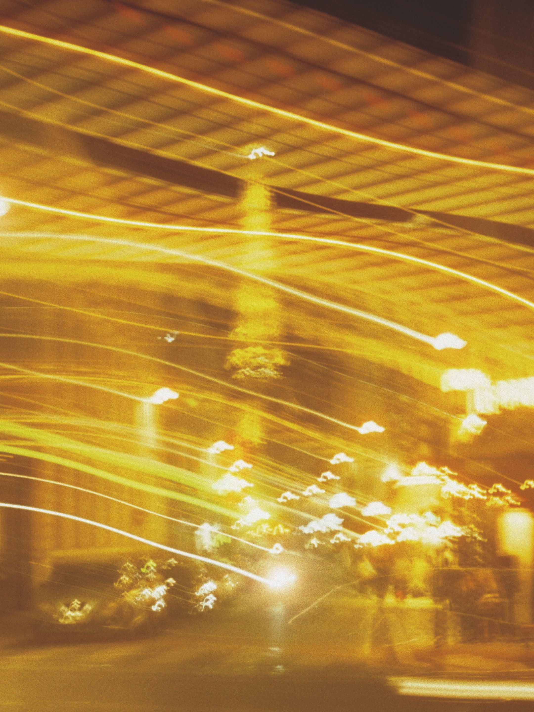 A vibrant, abstract blur of city lights captured at night, creating a mesmerizing visual effect.