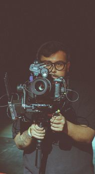 A professional videographer holding a camera during a film-making session.