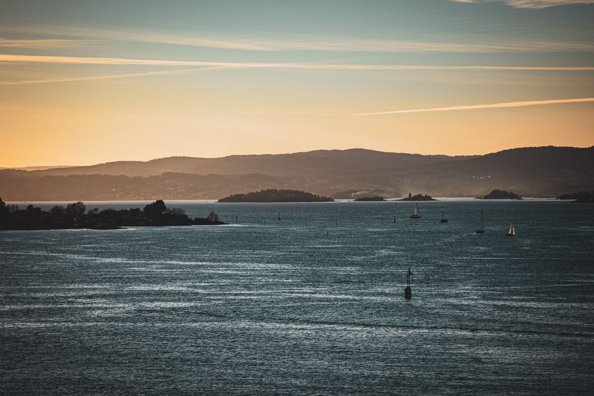 Sunset over Oslo Fjord with sailboats on calm water