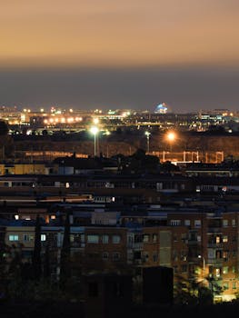 Glimmering capture of Madrid skyline at night, showcasing urban architecture and vivid lights.