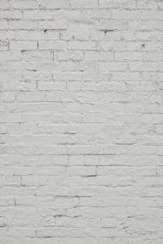 A close-up of a white-painted brick wall with textured details.