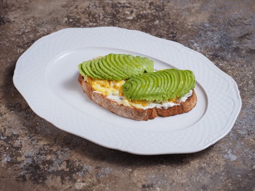 Free Brown Bread with Sliced Avocado on White Ceramic Plate Stock Photo