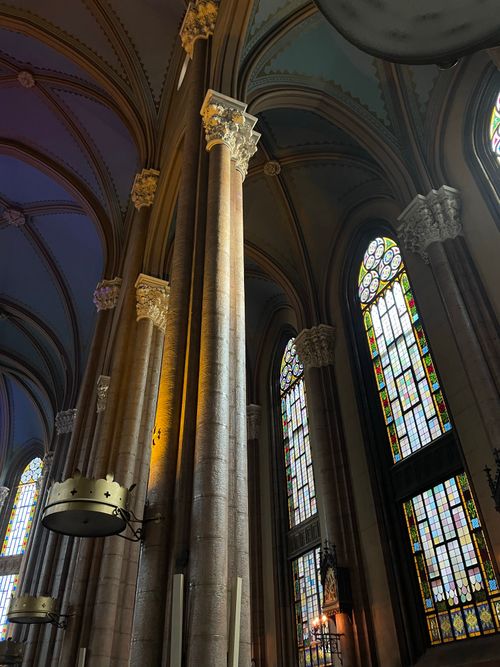 Free Majestic Gothic cathedral interior featuring stained glass windows and towering columns. Stock Photo