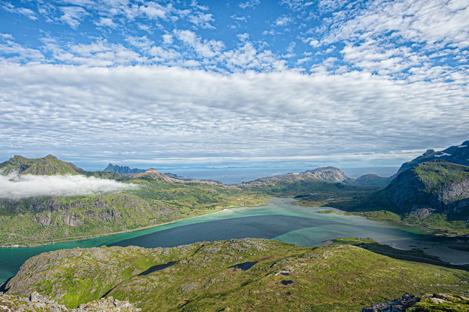 Breathtaking Minibus Northern Lights Chase with Photography from Tromsø Review 2026 - A breathtaking aerial view of a lush green landscape with a tranquil lake and majestic mountains under a vibrant blue sky.