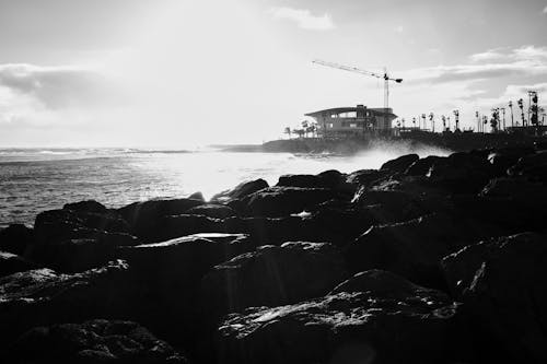 Grayscale Photo of Rocks on the Shore