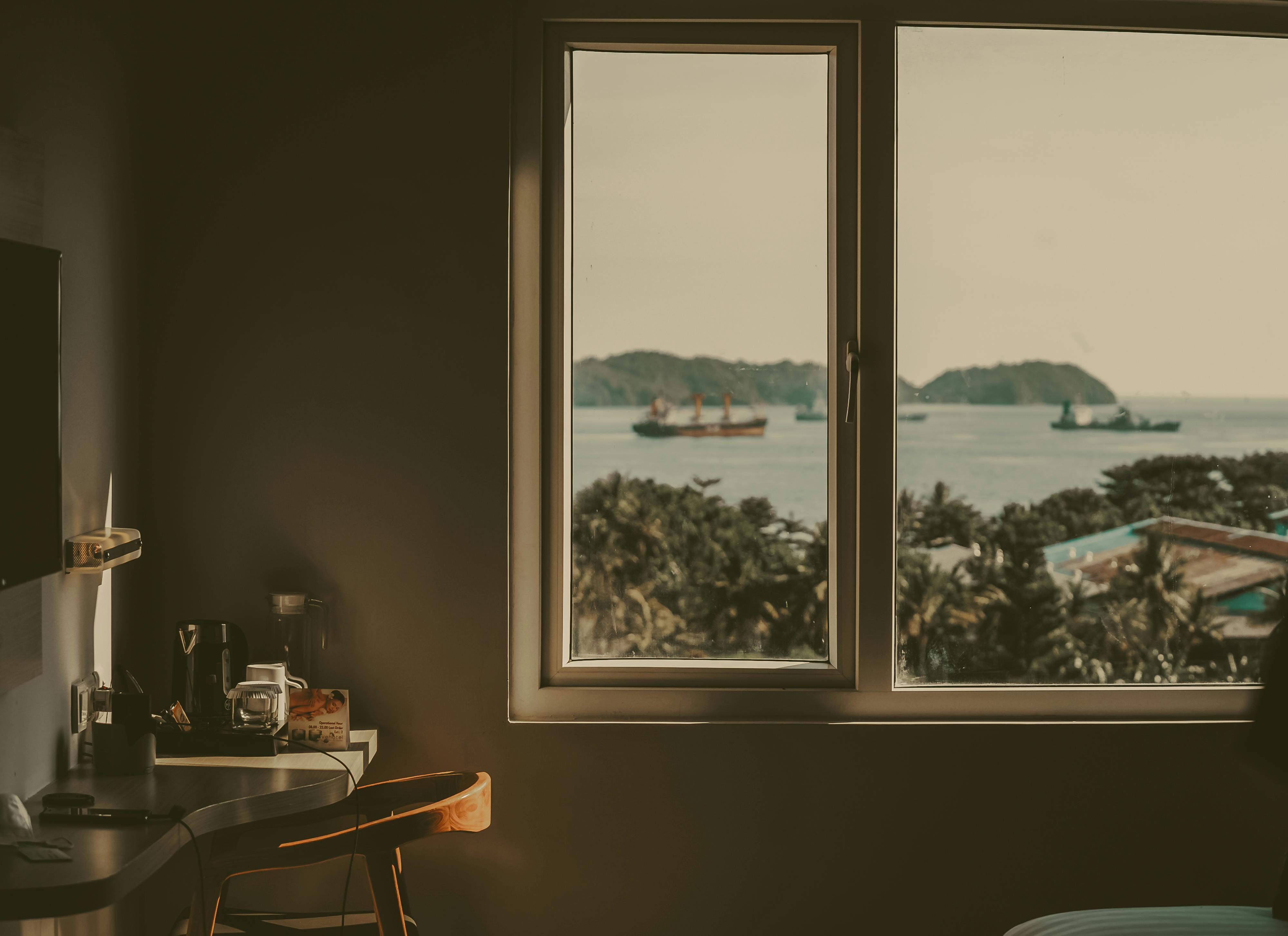furniture shipping - Calm Indonesian sea view from a cozy room window with ships in the distance.
