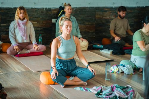 Free Group practicing meditation and yoga indoors in Rishikesh, India. Stock Photo