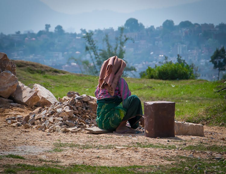 Woman Sitting By The Stack Of Rocks 