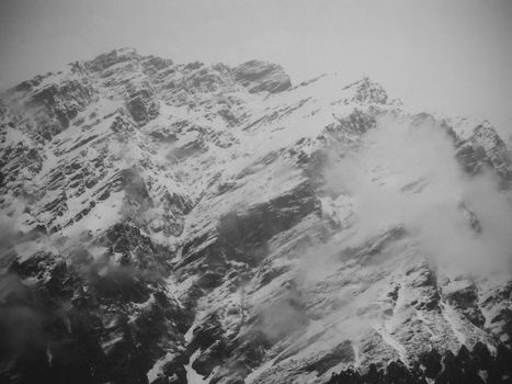 Stunning monochrome image of snow-covered mountain peaks, capturing the dramatic beauty of Manali.