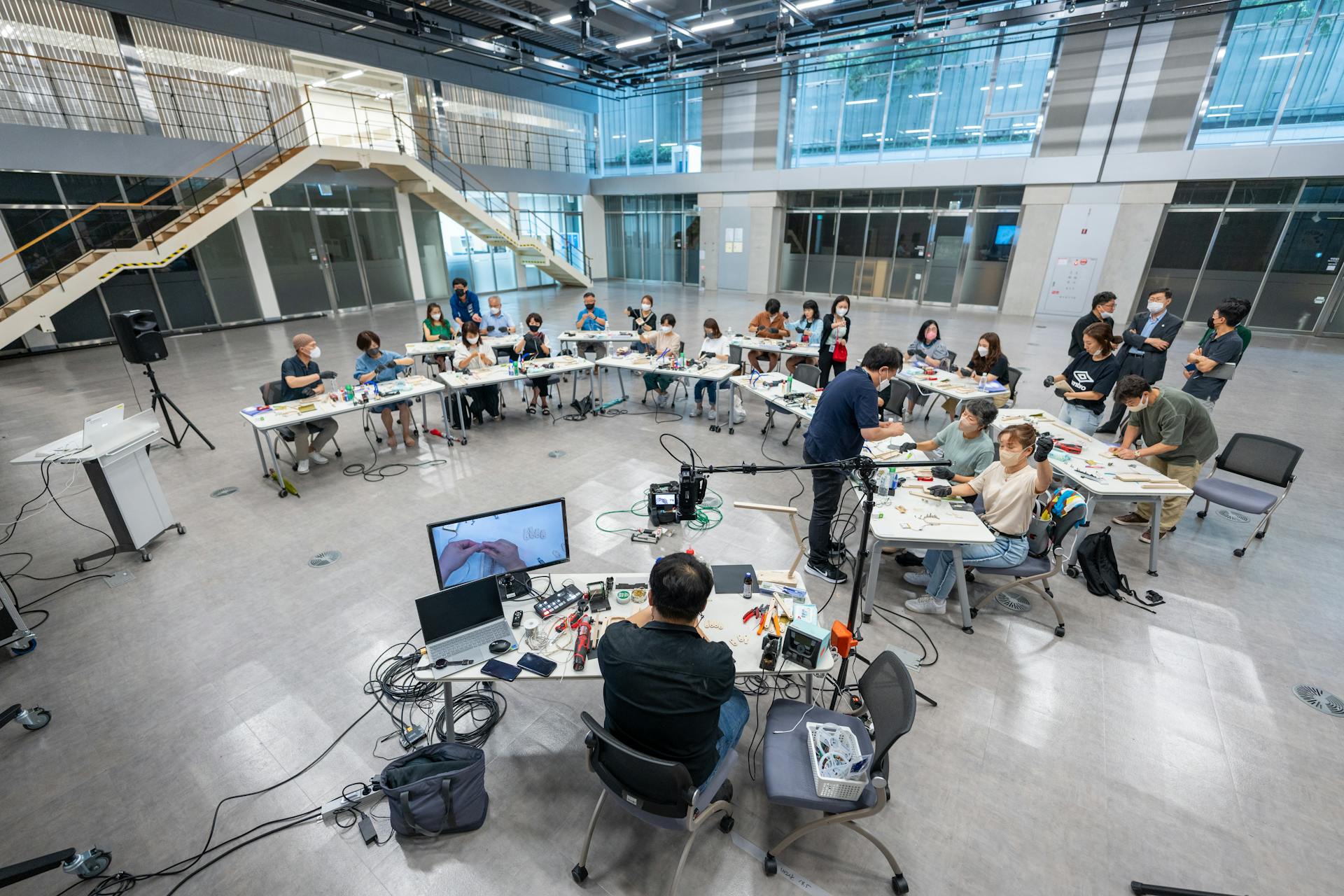 Wide shot of students in a modern university classroom engaging with technology and learning.