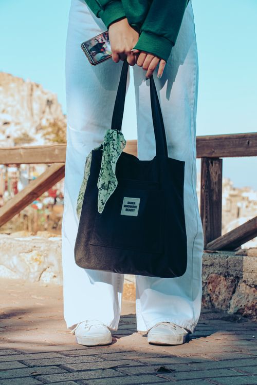 Free A person holding a tote bag outdoors in scenic Uçhisar, Turkey. Casual fashion meets travel. Stock Photo