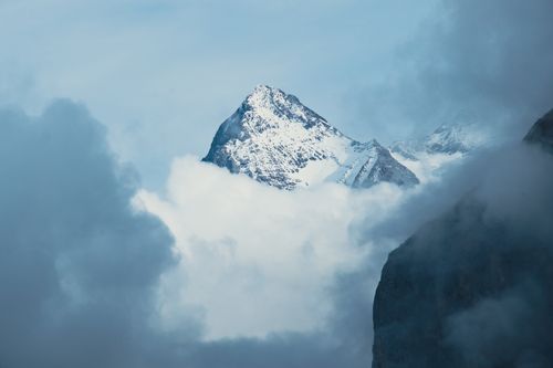Free A captivating view of a snow-capped mountain peak emerging through the clouds. Stock Photo