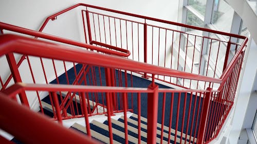 Blue and White Wooden Stairs With Red Metal Handrails