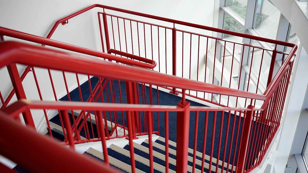 Free Blue and White Wooden Stairs With Red Metal Handrails Stock Photo