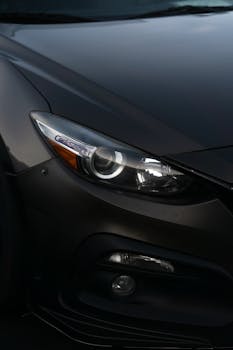 Close-up shot of a sleek black car's headlight showcasing modern design.