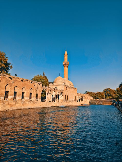 Free Scenic view of Rizvaniye Mosque and its iconic minaret by the river in Sanliurfa, Turkey. Stock Photo