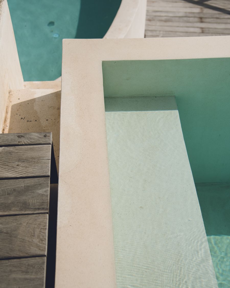 The corner of a warm pool meeting a wooden deck, seen from above
