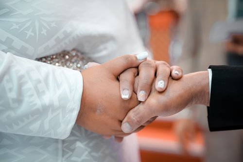 Free Detailed close-up of a bride and groom holding hands during their wedding ceremony. Stock Photo