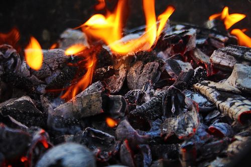 Free Close-up of burning embers with vibrant flames, creating a warm and fiery atmosphere. Stock Photo