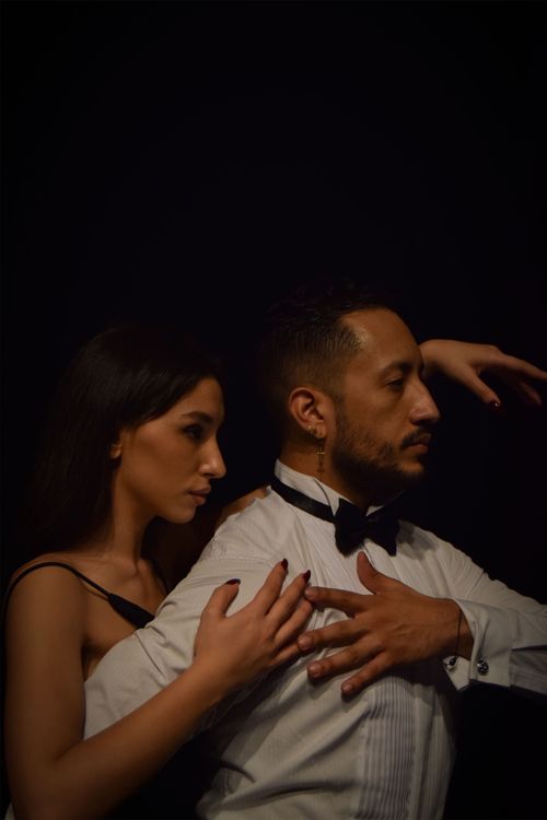 Free A romantic portrait of a couple embracing against a dark backdrop. Stock Photo