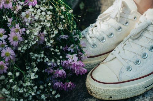 Free Close-up of white sneakers next to lavender flowers, creating a delicate floral composition. Stock Photo