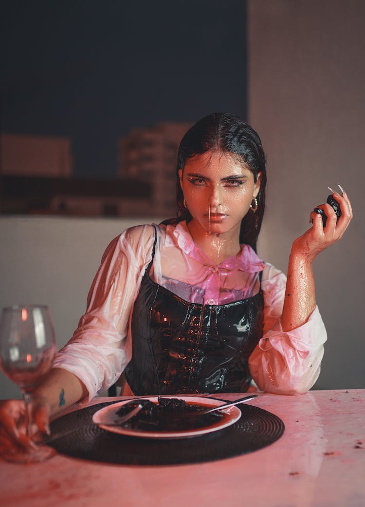 Woman In Wine Drenched Clothes And Face Sitting At The Table