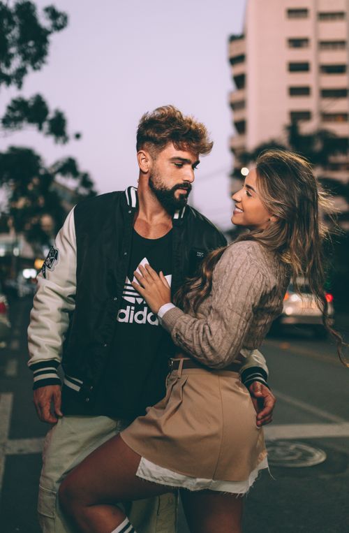 Free Couple embracing on an urban street with a romantic vibe at twilight. Stock Photo