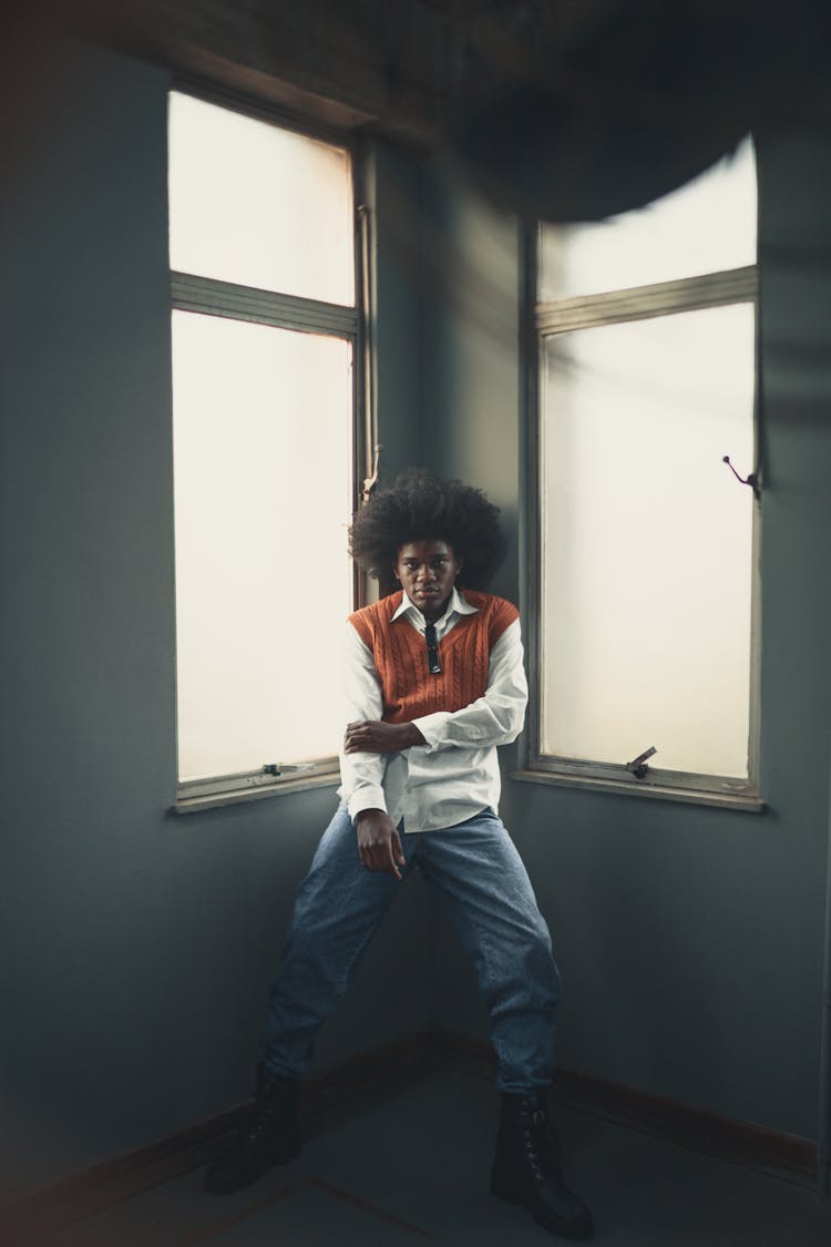 Young Man Standing In The Corner Of The Room