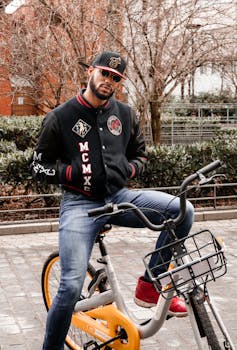 Fashionable man posing on a bike in urban New York City setting.