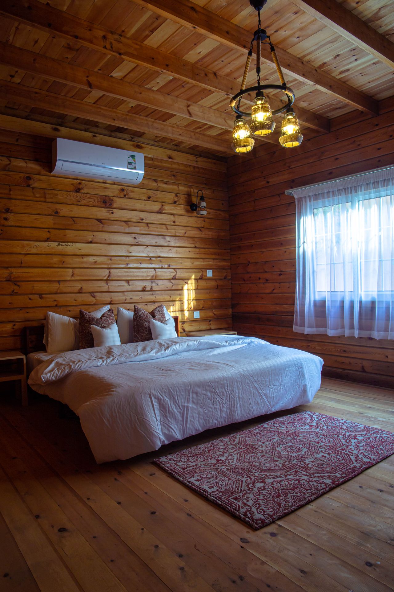 Cozy log-cabin bedroom with wood walls and white bedding