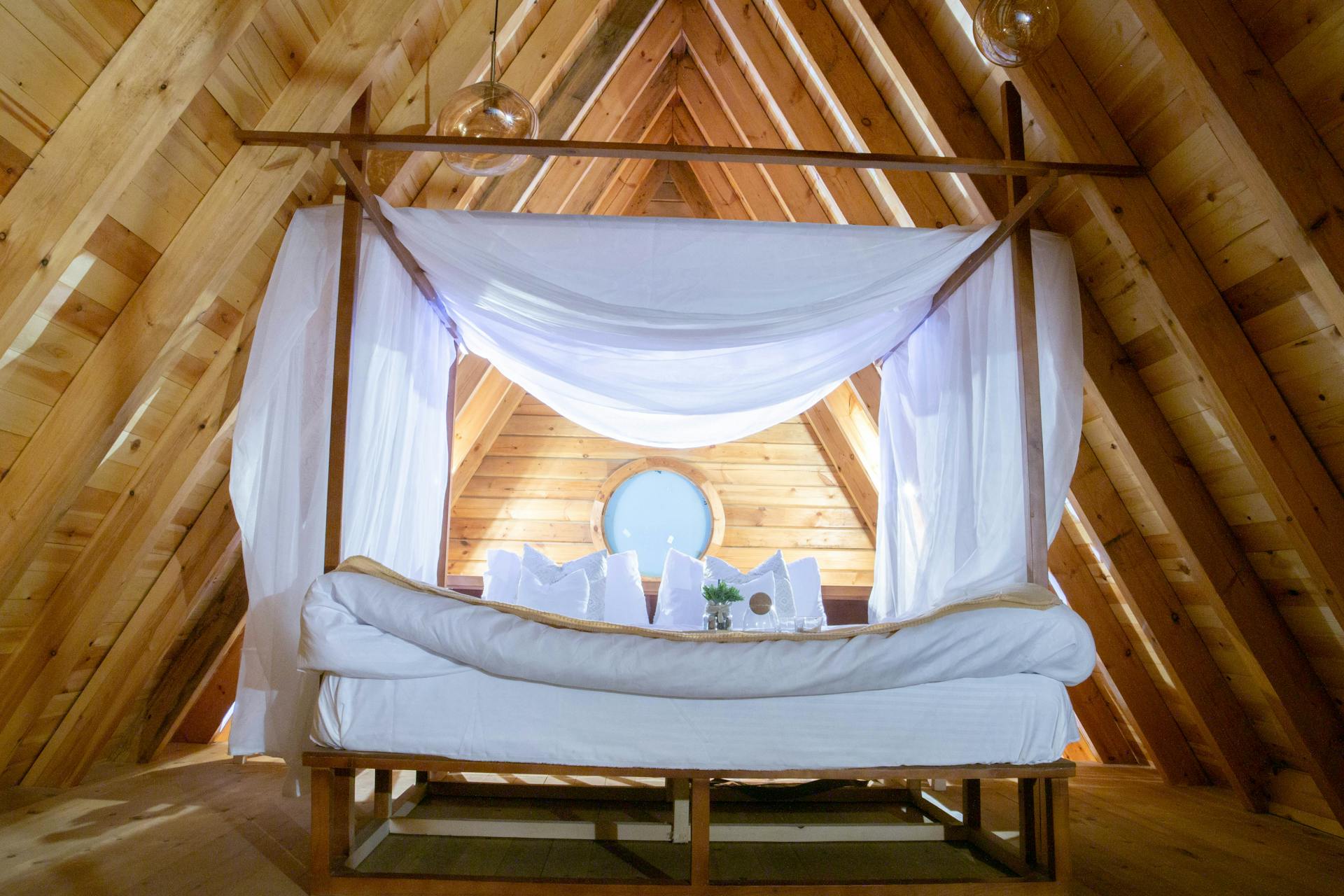Warm and inviting attic bedroom with a wooden design and a canopy bed setting