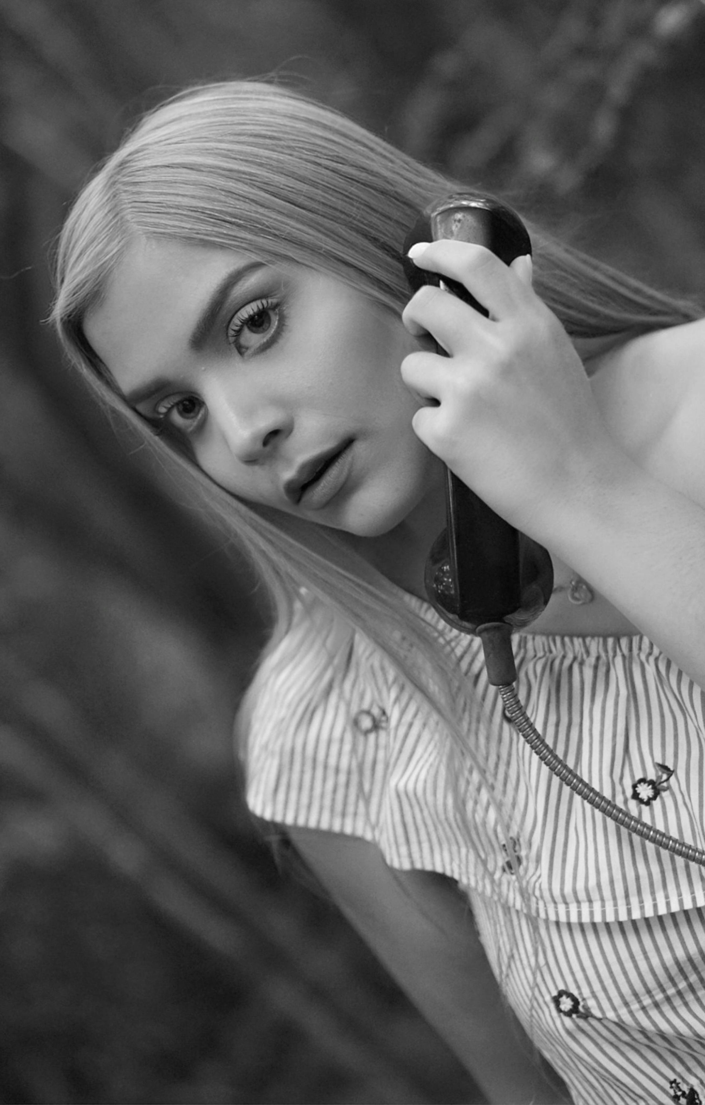 Free Black and white portrait of a woman holding a vintage telephone. Stock Photo