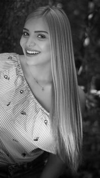 Elegant black and white portrait of a smiling woman with long hair, creating a timeless and classic look.