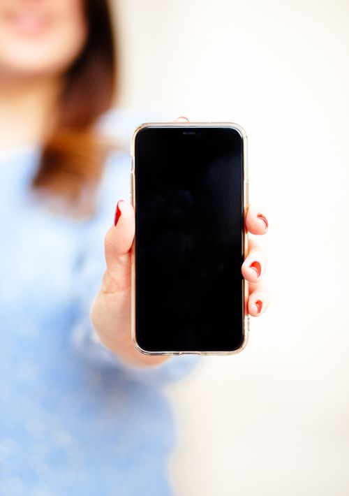 Free Close-up of a smartphone held by a woman in a New York studio setting. Stock Photo