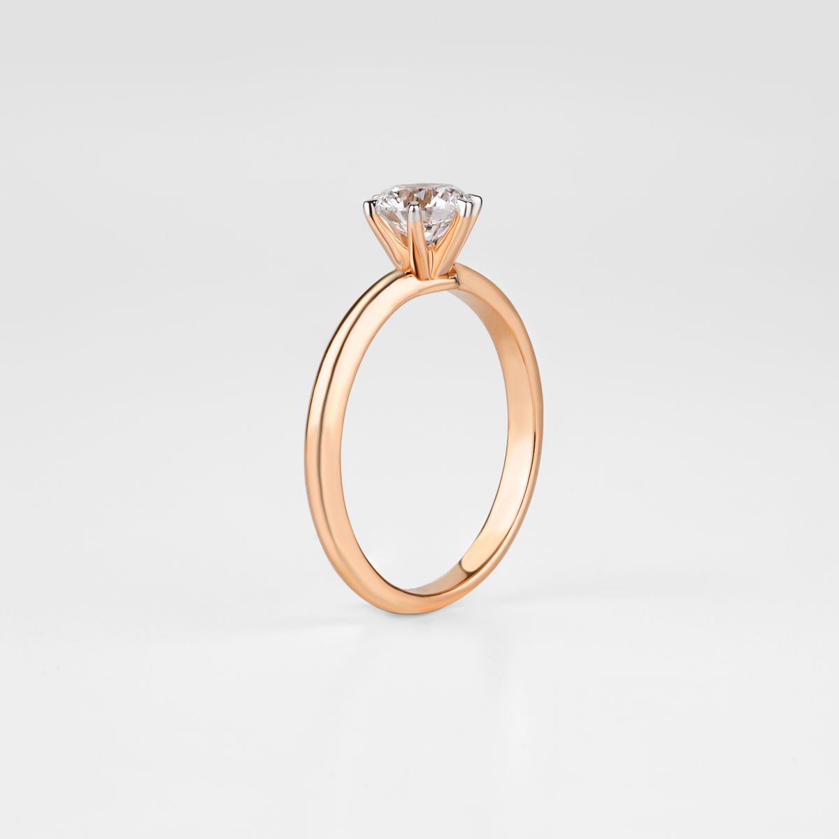 Gold solitaire diamond engagement ring on a clean white surface